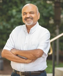 Atul Jain standing with his arms crossed in front of him.